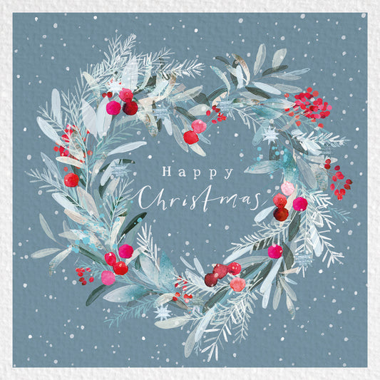Heart-shaped winter wreath with frosted foliage and red berries, surrounding the words “Happy Christmas” on a snowy blue background.