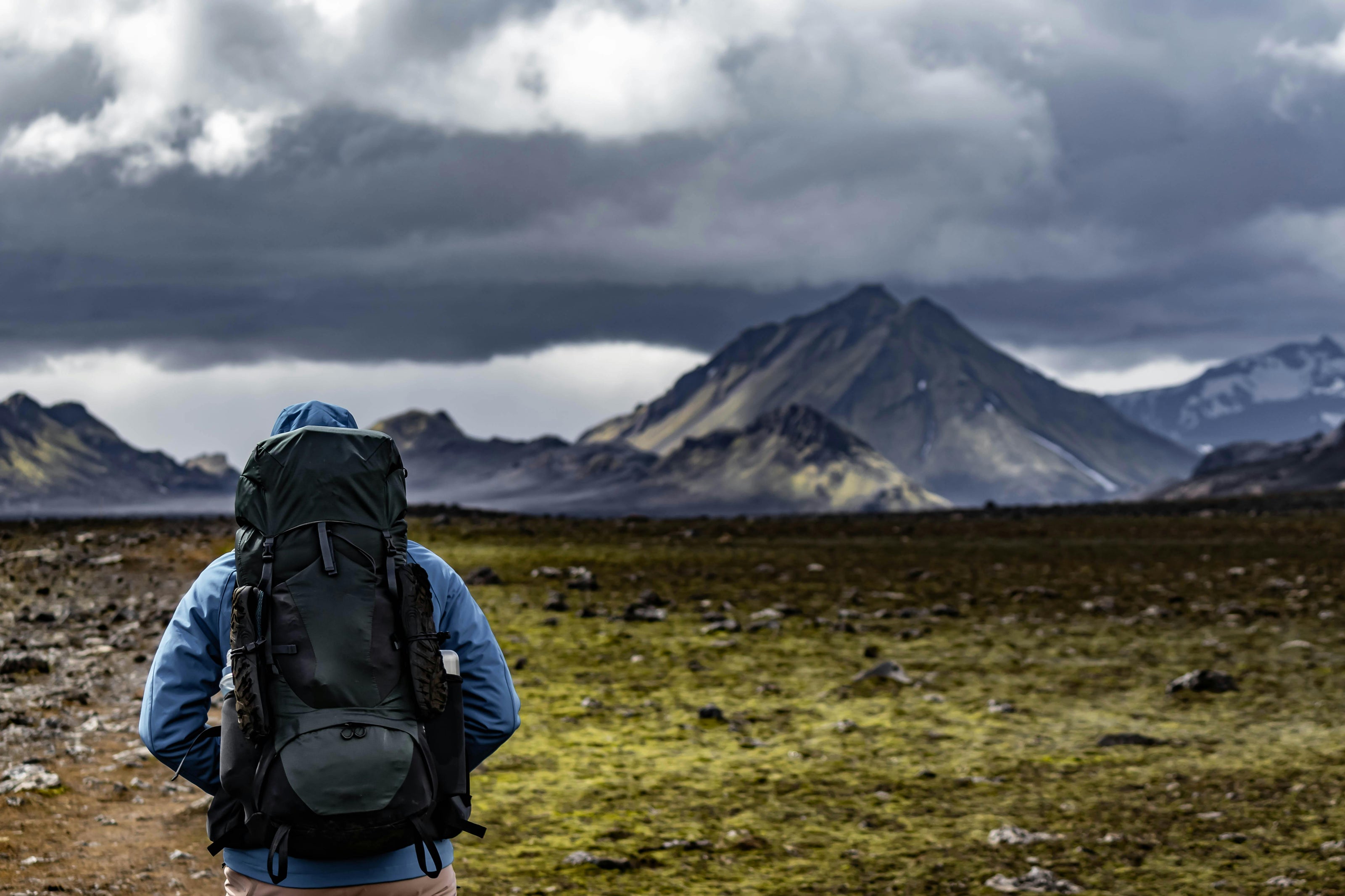 Person with a backpack looking at mountain