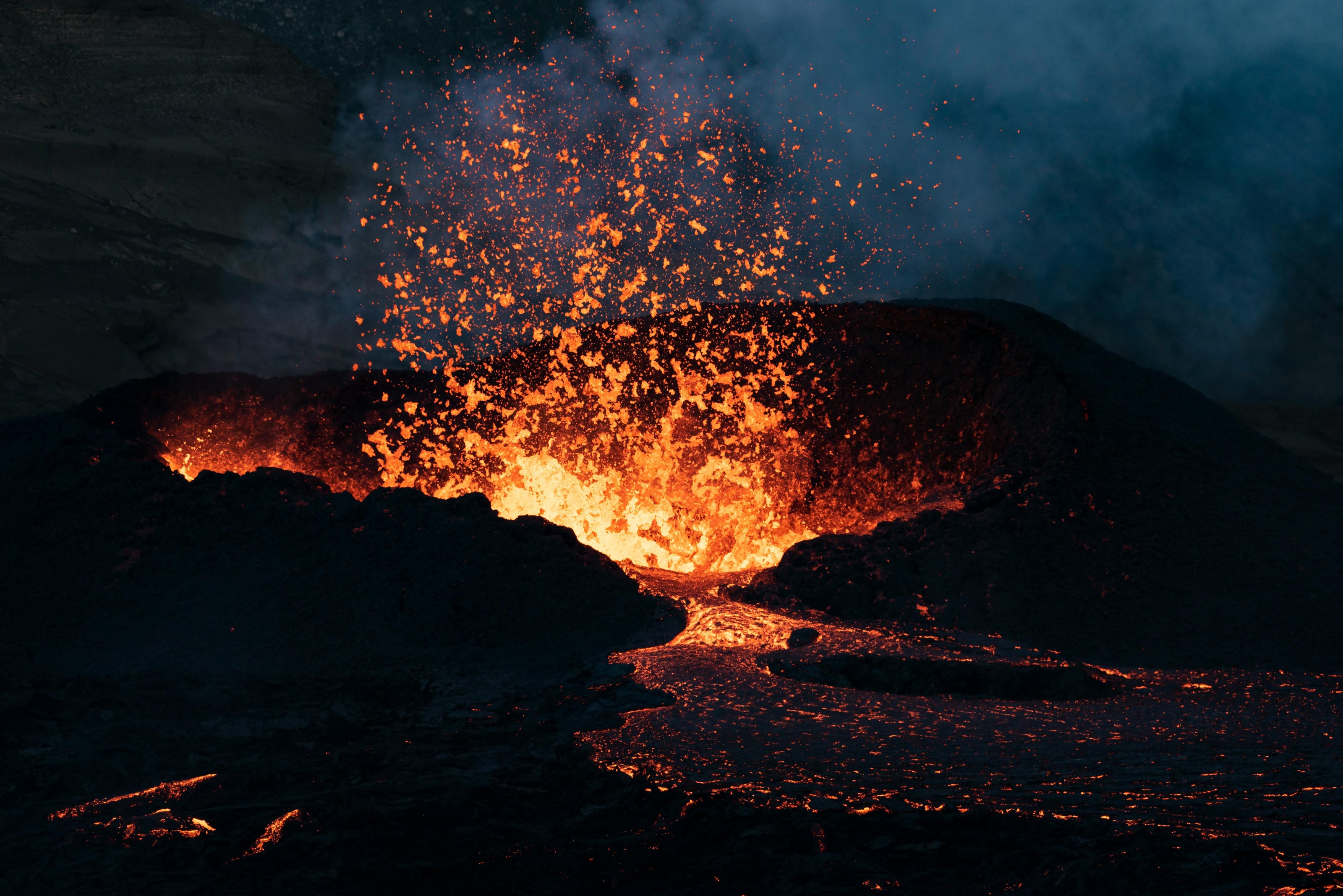 Volcanic eruption with lava and ash in a dark setting